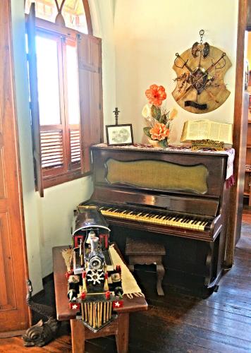 a piano in a room with a toy train next to it at Pousada Estação do Trem in São João del Rei