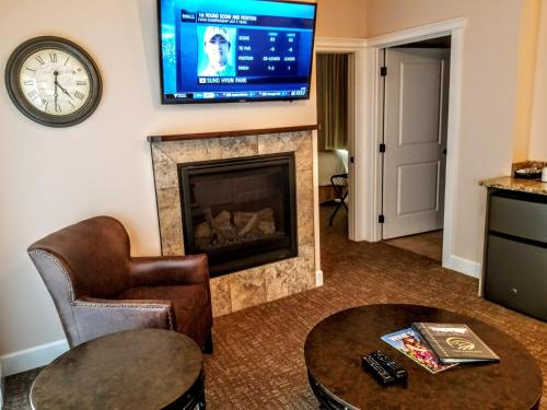 a living room with a fireplace and a flat screen tv at Resort at Eagle Point Golf Club Lodging in Medford