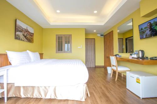 a bedroom with a bed and a desk with a computer at Chamnan Residence in Hat Yai