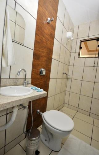 a small bathroom with a toilet and a sink at Hotel Astoria in Palmas