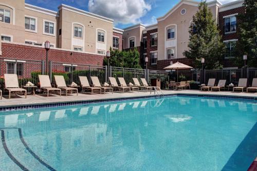 uma piscina com espreguiçadeiras e um edifício em Hyatt House Philadelphia/Plymouth Meeting em East Norriton