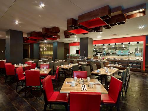 un restaurante con mesas de madera y sillas rojas en Hyatt Regency Cincinnati, en Cincinnati