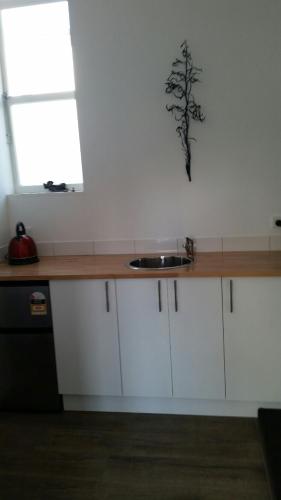 a kitchen counter with a sink and a window at Mauao Studio in Mount Maunganui