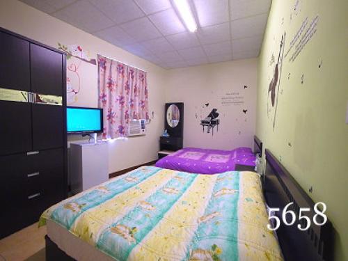 a bedroom with a bed and a flat screen tv at Hua Qiao De Jia in Donggang