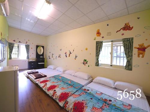 a bedroom with two beds in a room at Hua Qiao De Jia in Donggang