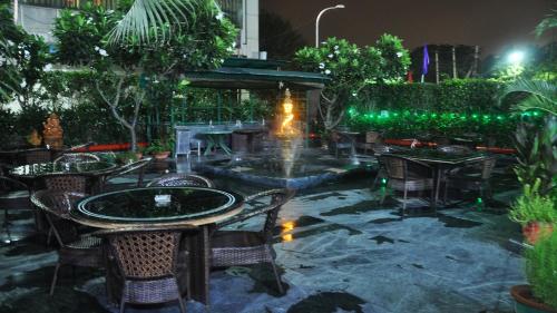a patio with a fountain and tables and chairs at SkyCity Hotel Gurgaon in Gurgaon