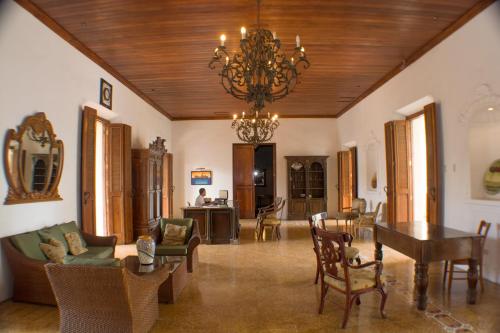a living room with a chandelier and a table and chairs at Hotel la Perla Leon in León