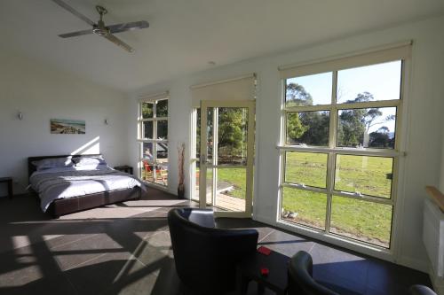 a bedroom with a bed and a large window at Riverwalk B&B in Robigana