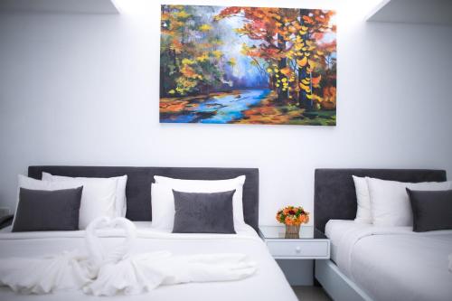 a bedroom with two beds and a painting on the wall at Chiangmai Midpoint Activity Hostel in Chiang Mai