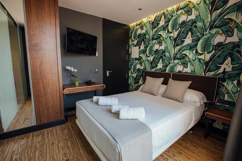a bedroom with a white bed with a floral wall at Málaga Premium Hotel in Málaga