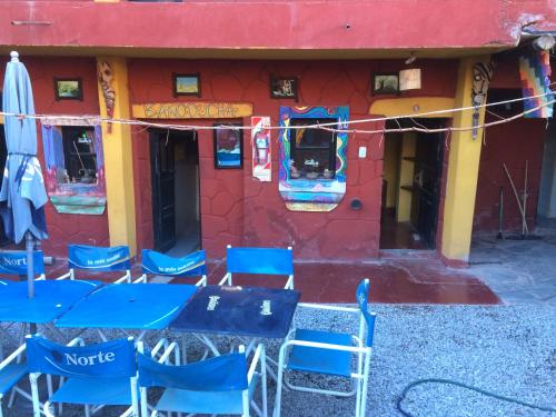 a group of blue tables and chairs in front of a building at Tilcara Mistica Hostel in Tilcara