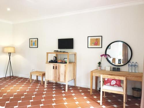 a living room with a tv and a mirror at Peppercorn Beach Resort in Phu Quoc