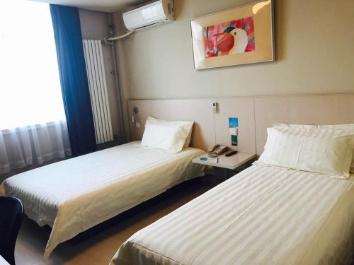 um quarto de hotel com duas camas e um telefone em Jinjiang Inn - Beijing Olympic Village Datun Road em Pequim