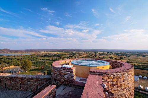 an outdoor hot tub on top of a stone wall at Ramathra Fort in Sapotra