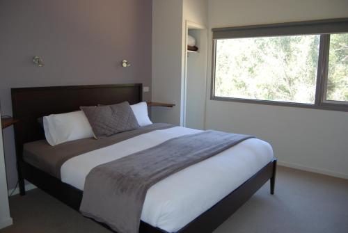 um quarto com uma cama grande e uma janela em Bellbrae Harvest em Torquay