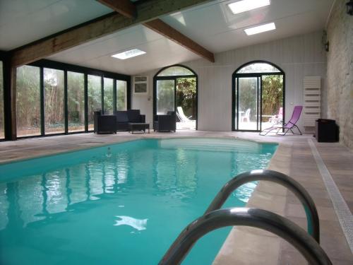 - une piscine d'eau bleue dans un bâtiment avec fenêtres dans l'établissement La Parenthèse avec piscine - les impressionnistes, à Frépillon