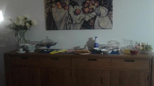 a wooden cabinet with food on it with a painting on the wall at b&b Ergira in Cividale del Friuli