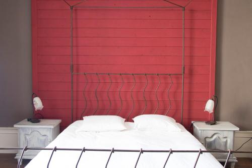 a bedroom with a red wall and a bed at Joie de Vivre in Doulevant-le-Château