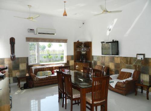 a living room with a table and chairs at Farmers Villa in Amritsar