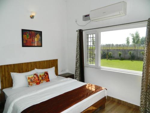 a bedroom with a bed and a large window at Farmers Villa in Amritsar