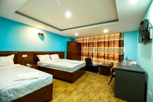 um quarto de hotel com duas camas e uma secretária em Everest Holiday Inn em Kathmandu