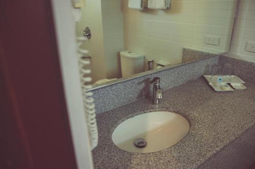 a bathroom counter with a sink and a mirror at El Cielito Inn - Baguio in Baguio