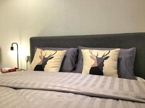 a bed with three deer pillows on it at iBook Gurney Suites in George Town