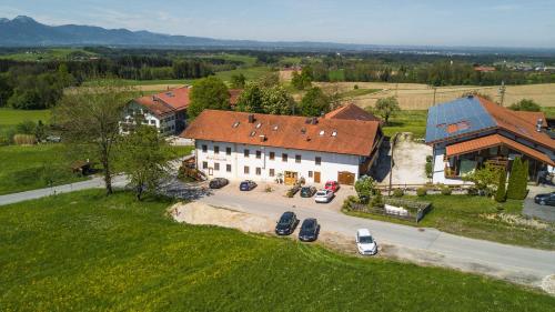 een luchtzicht op een groot huis met auto's geparkeerd op een parkeerplaats bij Hotel Alpenblick in Riedering