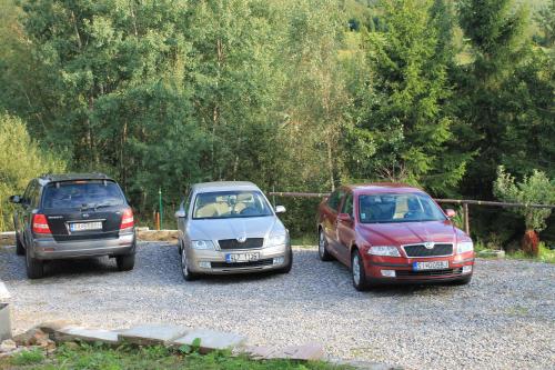 three cars parked in a gravel parking lot at Ubytovanie Eva in Oščadnica