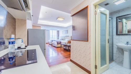 a kitchen and a living room with a sink at The Legend Nuomo Service Apartment in Guangzhou