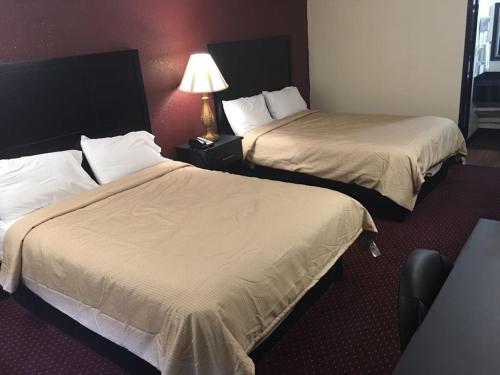 a hotel room with two beds and a lamp at Super 9 Motel Troy in Troy