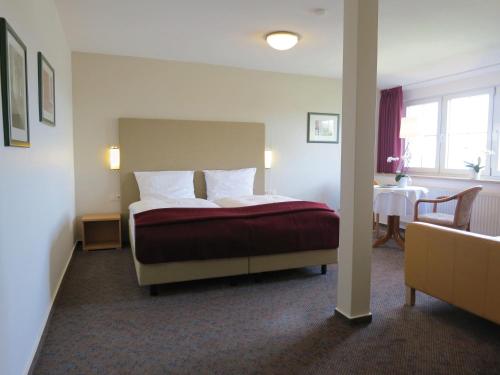 um quarto de hotel com uma cama e uma mesa em Hotel Seeblick Garni em Plön