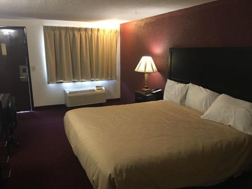 a hotel room with a large bed and a window at Super 9 Motel Troy in Troy
