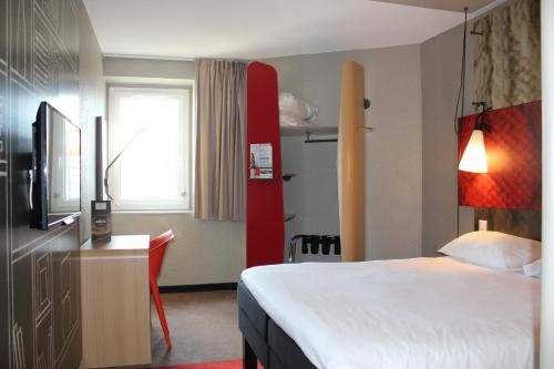 a hotel room with a bed and a desk at ibis Saint Malo Plage in Saint Malo