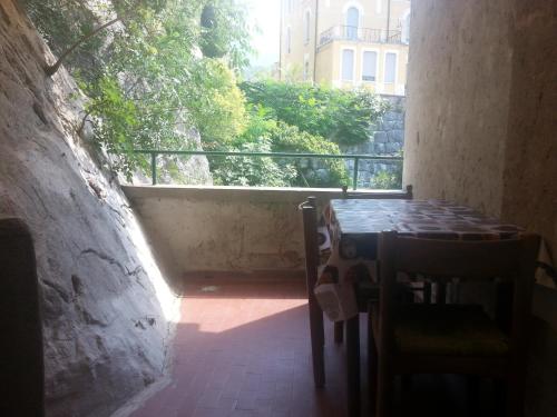 ナーゴ・トルボレにあるAppartamento Villa Olivoのバルコニー付きの客室で、テーブルと椅子が備わります。