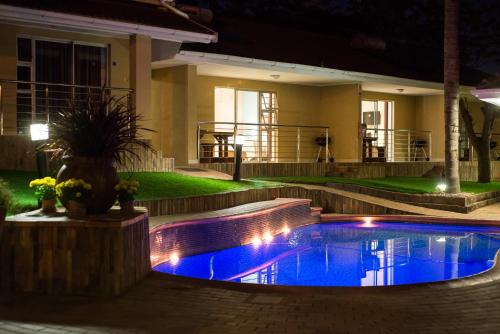 a swimming pool in front of a house at night at TeBeacon Accommodation in East London