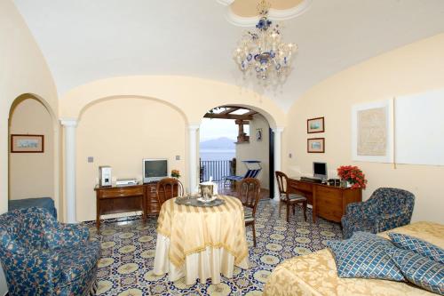 a living room with a table and a desk at Hotel La Tonnarella in Sorrento