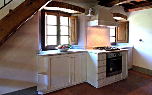 a kitchen with a stove top oven next to a window at Tenuta Poggio Marino in Dicomano