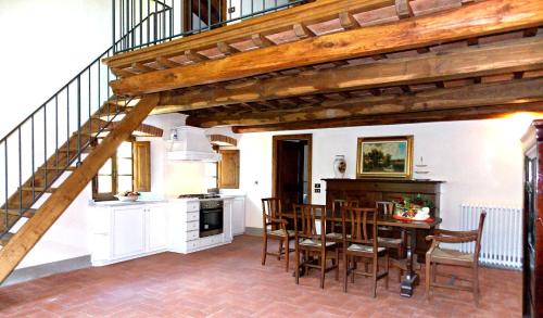 a kitchen and dining room with a table and a staircase at Tenuta Poggio Marino in Dicomano