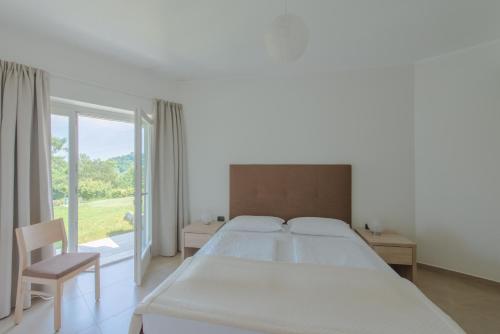 a white bedroom with a large bed and a window at Villa Maria in Tremosine Sul Garda