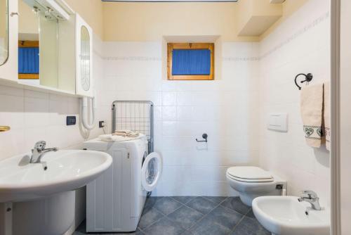 a white bathroom with a toilet and a sink at Casa Albinelli in Cutigliano