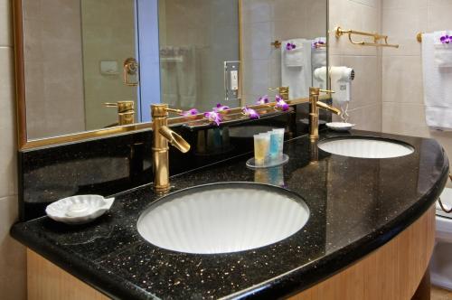 a bathroom counter with two sinks and a mirror at Castle Bamboo Waikīkī Hotel in Honolulu