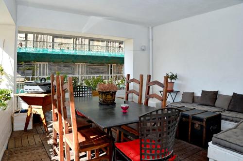 un salon avec une table, des chaises et un canapé dans l'établissement Le Phocéen Appartement Terrasse Plein centre, à Marseille