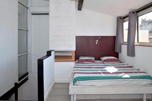 マルセイユにあるLe Panier Duplex Centre historique terrasse proche Vieux Portのベッドルーム1室(ベッド2台、窓付)