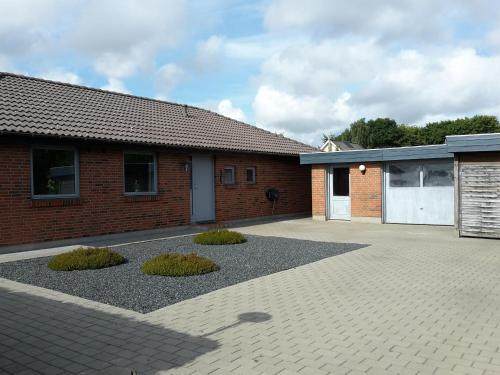 a brick building with a driveway and a garage at Villa in Brande in Gammel Blåhøj
