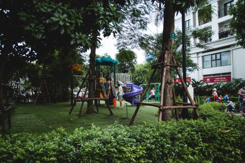 a playground in a park with people playing on it at Full House Times City in Hanoi
