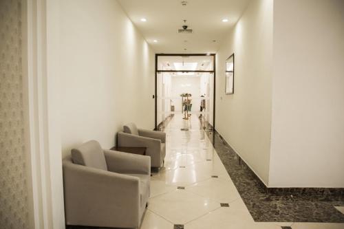 a hallway with chairs and people walking down a hall at Full House Times City in Hanoi