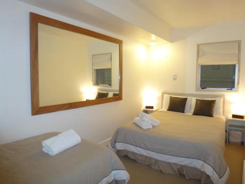 a hotel room with two beds and a mirror at Lakefront Apartments,18 LAKE ESPLANADE ROAD in Queenstown