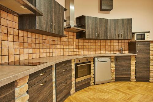 a kitchen with wooden cabinets and a counter top at B3 Hostel Budapest in Budapest