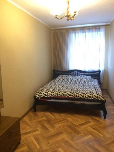 a bedroom with a bed in a room with a window at Apartments on Kirova 16 in Simferopol